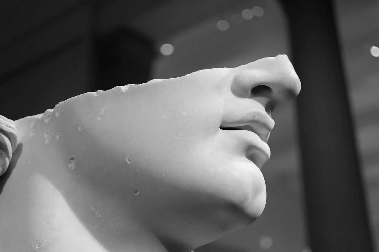 Close-up of a classical sculpture's face in black and white.
